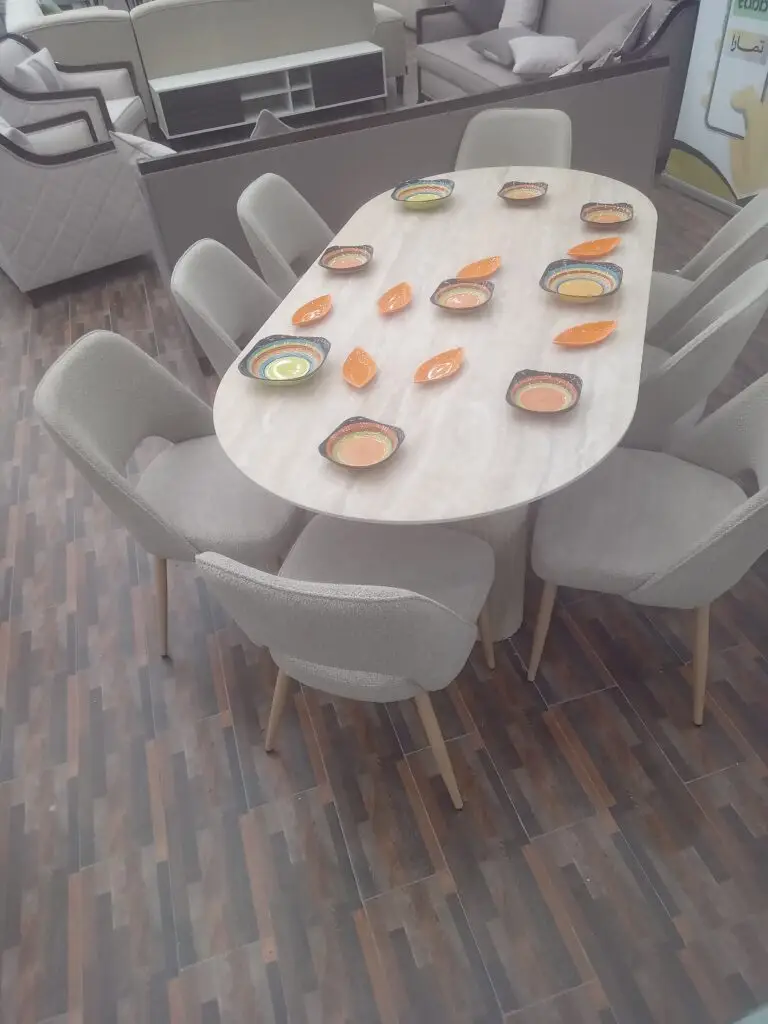 طاولة طعام سيراميك بيضاوية مودرن بأرجل خشبية فاتحة مع كراسي بوكليت من فريدة للأثاث